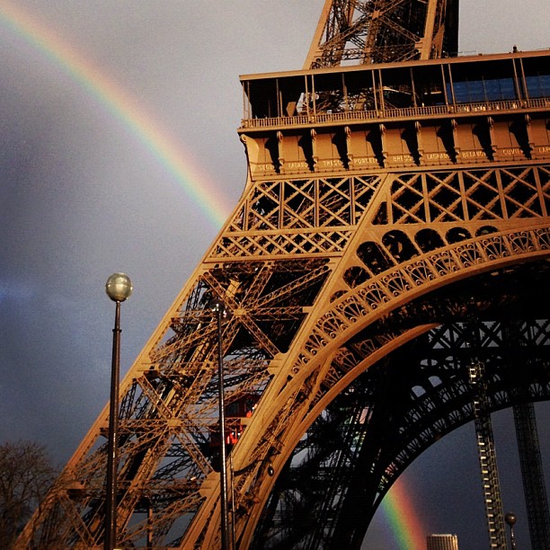 Close-up of Eiffel Tower with rainbow in background