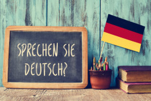 German flag with chalkboard reading "Sprechen sie deutsch?"