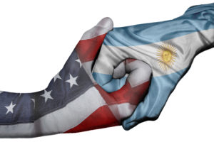 Hands interlocked with USA and Argentina flags
