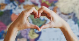 Heart hands in front of map | AIFS Study Abroad