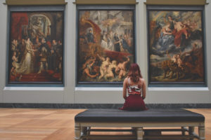 Woman facing painting in an art gallery or museum