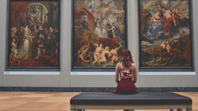 Woman facing painting in an art gallery or museum