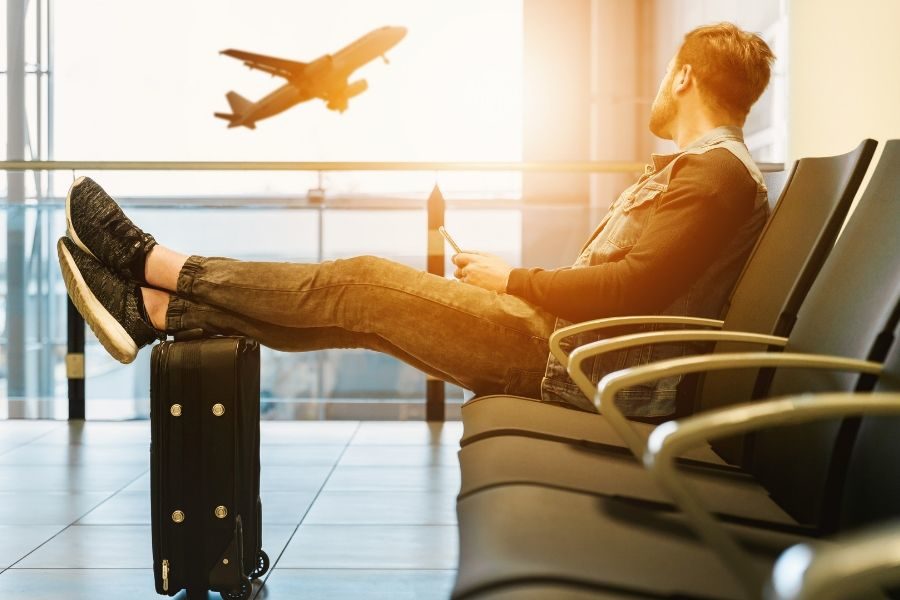 Young person waiting at the airport with suitcase | 3 Things You Might Feel During the Acclimation Phase of Study Abroad