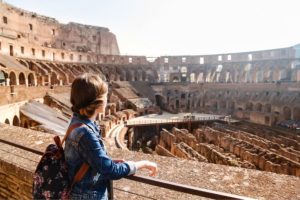 College student with backpack at the Colosseum in Rome - Discount to study abroad in Rome for spring semester | AIFS Study Abroad