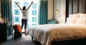 Happy traveler in a hotel room | AIFS Study Abroad