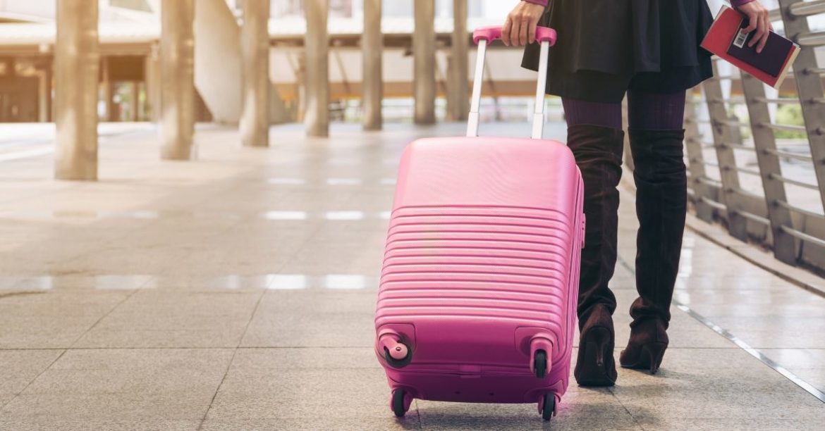 Woman pulling suitcase in airport | AIFS Study Abroad