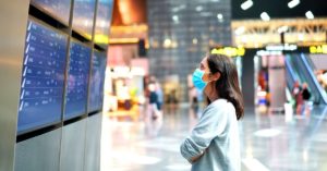 Young woman in airport wearing a mask | AIFS Study Abroad