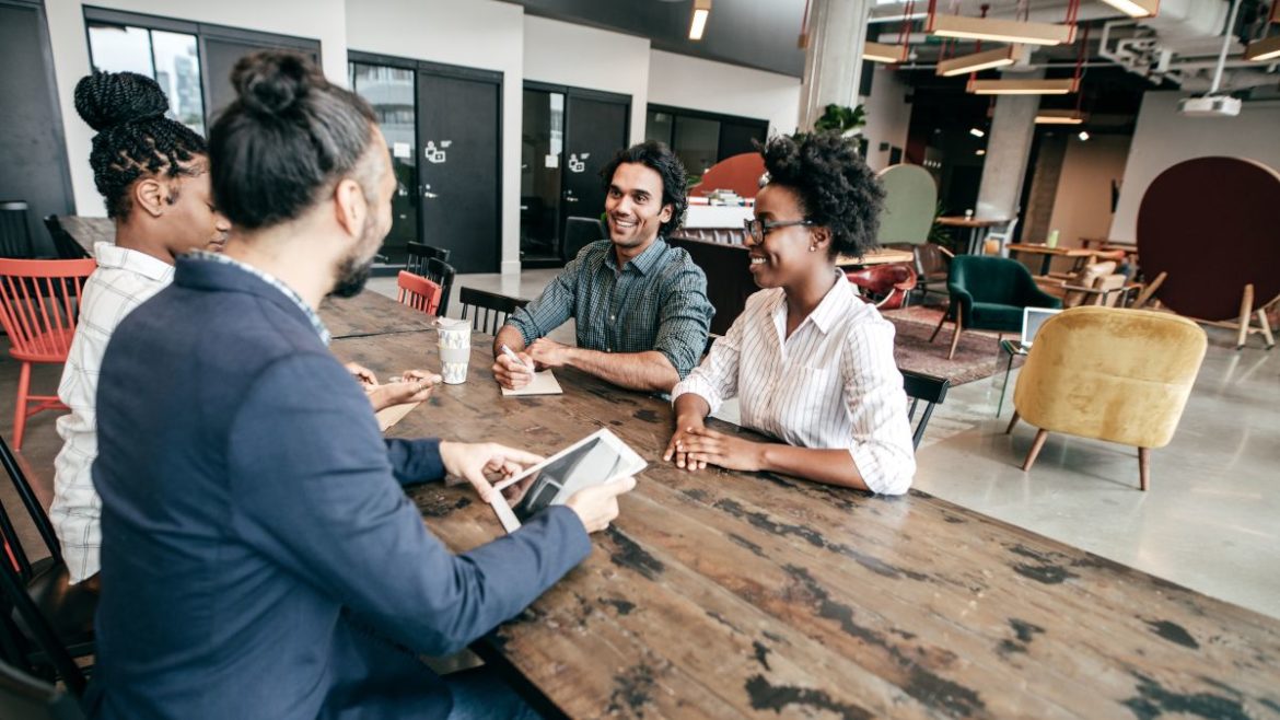 Group of interns sitting at a table in an office setting