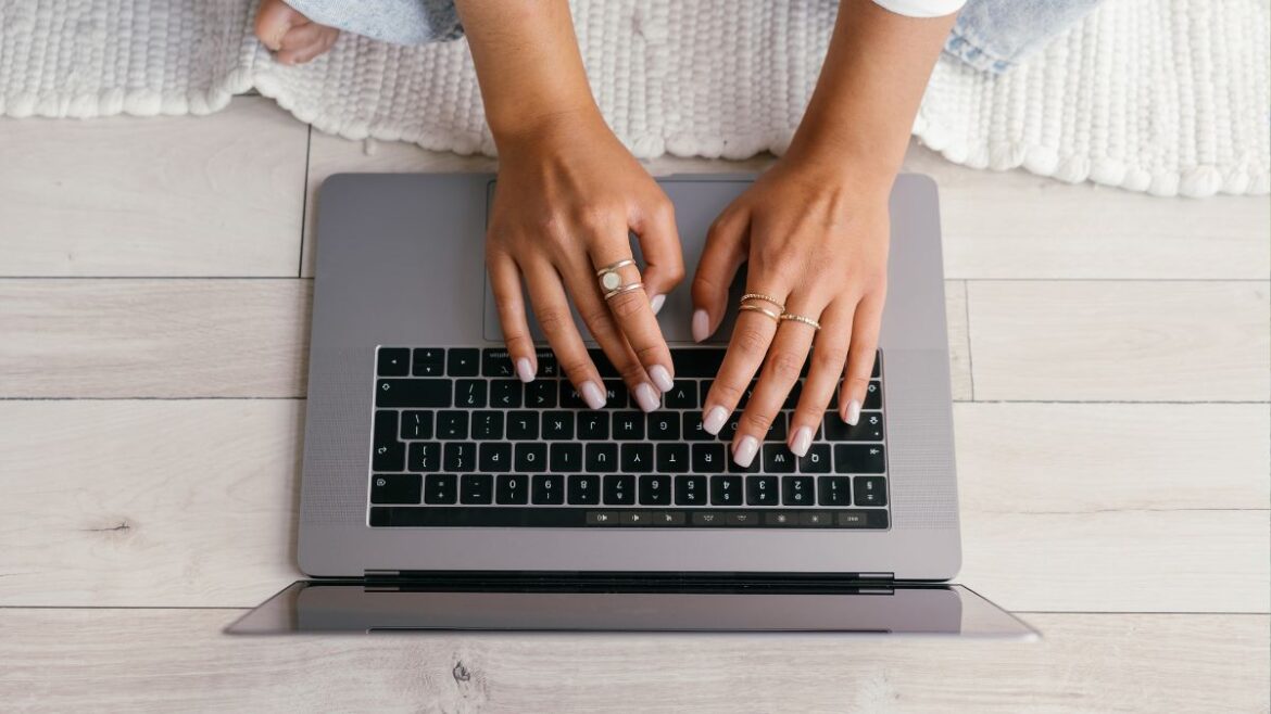 Hands typing on a laptop