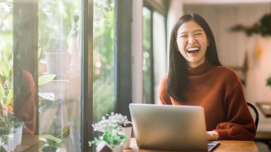 Happy young woman working on laptop