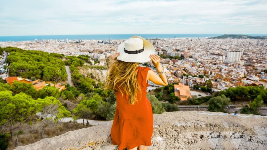Woman overlooking Barcelona, Spain cityscape during summertime
