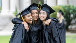 three female recent college graduates at graduation