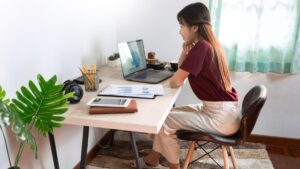Young woman working at home at desk as an intern