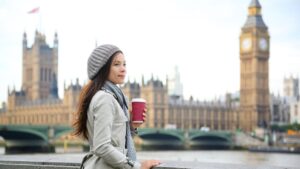 Young woman in London, England during winter at Big Ben on the River Thames
