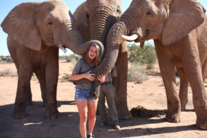 AIFS Abroad study abroad student in South Africa with three elephants