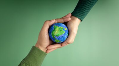 Two hands holding small globe - sustainability and environmental studies concept