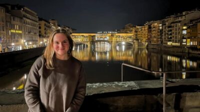 aifs abroad student in front of ponte vecchio in florence, italy at night while studying abroad
