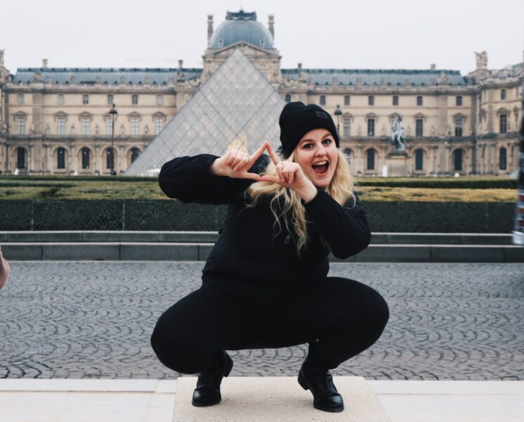 AIFS Abroad student in Paris, France at the Louvre with sorority hand symbols