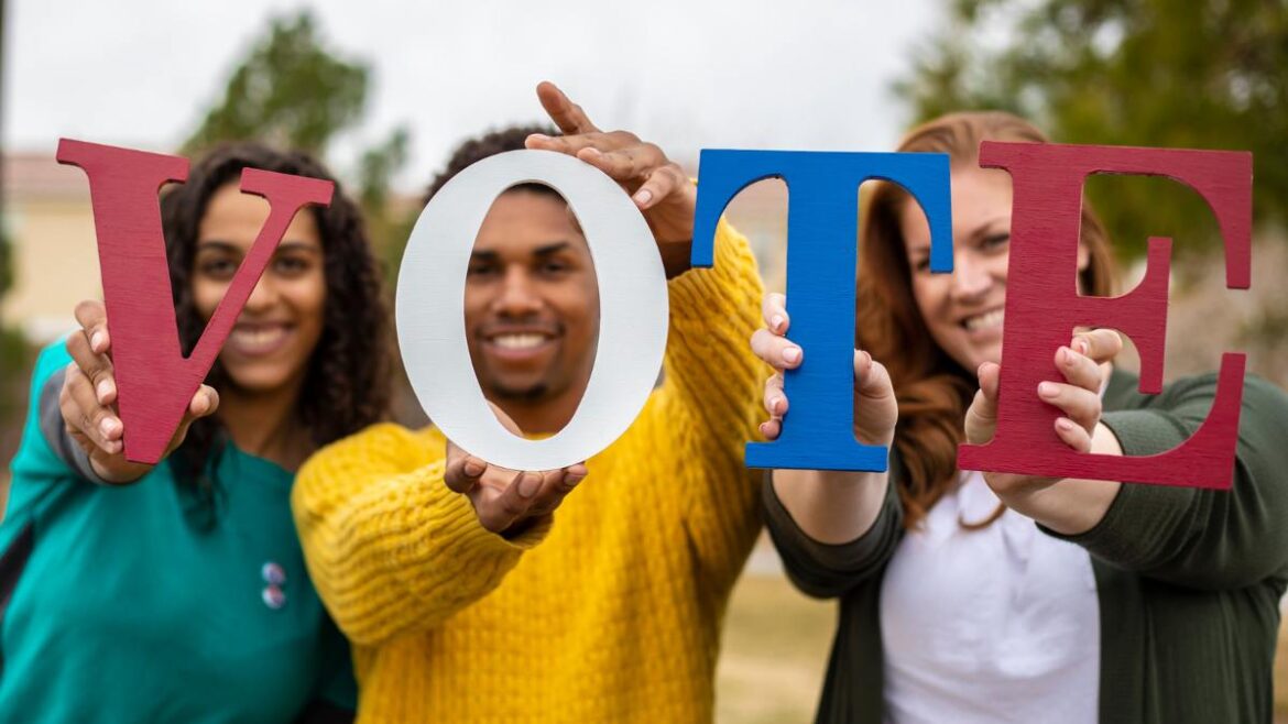 Young people holding letters that spell VOTE