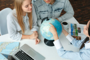 Young man and woman in a tour agency with a travel agent