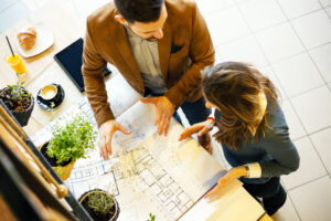 Architects discussing building plans during a meeting in a modern cafe.