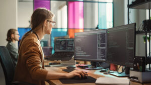 Female Software Engineer Writing Code on Desktop Computer