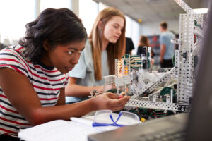 AIFS Abroad STEM majors - Two Female College Students Building Machine In Science Robotics Or Engineering Class