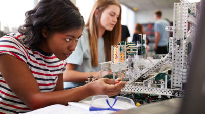 AIFS Abroad STEM majors - Two Female College Students Building Machine In Science Robotics Or Engineering Class